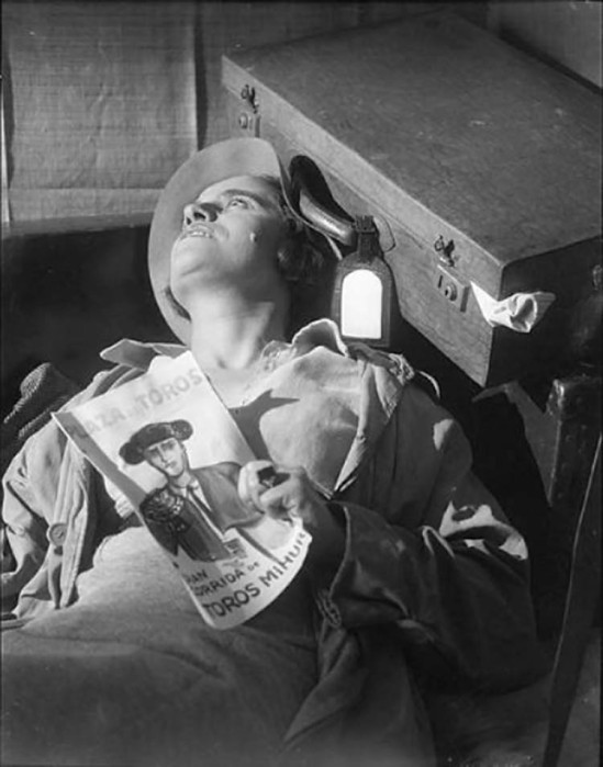 Roger Parry- Une femme étendue sur le dos, les yeux ouverts, la tête contre une valise et une revue de tauromachie dans une main1933